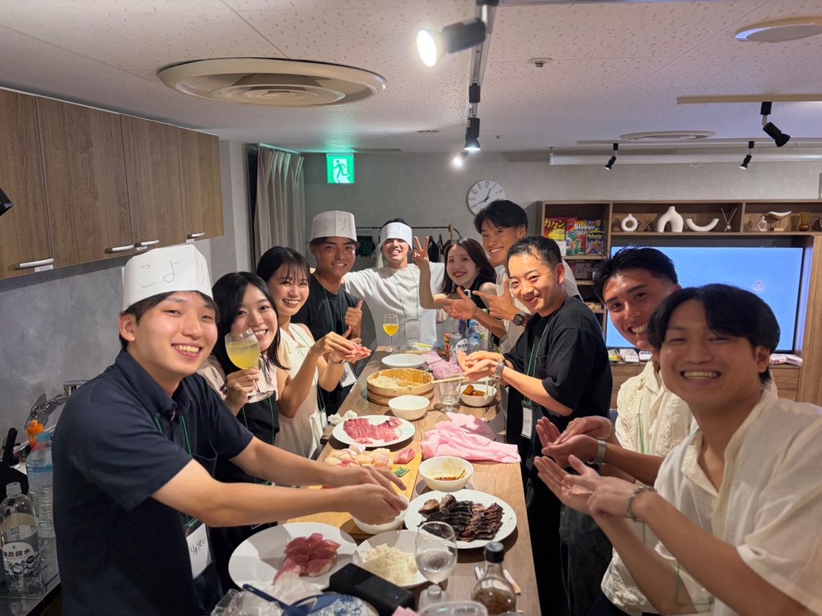 食卓を囲んで寿司を握る素敵会の参加者たち